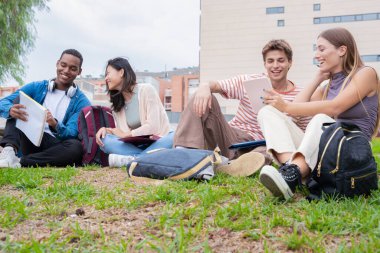 Farklı etnik çeşitlilikteki arkadaşlar dersten sonra dışarıda dinleniyorlar. Üniversite yaşam konsepti