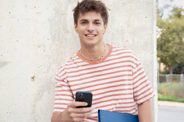 Mutlu öğrenci sosyal medya uygulaması kullanarak üniversite kampüsünde. Üniversite hayatı