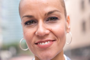 Beyaz iş kadını, takım elbiseli kameraya gülümseyen açık hava çalışma alanında duruyor. Olumlu bakışları olan genç bir avukatın önü.