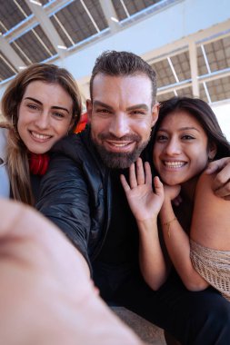 Mutlu çoklu etnik gruptan eşcinsel arkadaşlar kampüste selfie çekiyorlar. Şehirde buluşan çok ırklı öğrenciler, gençlik kavramları, insanların yaşam tarzı, çeşitlilik ve gurur..