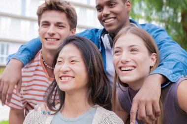 Bir grup arkadaş üniversitede selfie çekiyor ve birlikte gülüyorlar. Teknoloji ya da ağ kurma, bağlantı ve mutlu üniversiteliler sosyal medyaya gülümserken fotoğraf çekiyorlar.