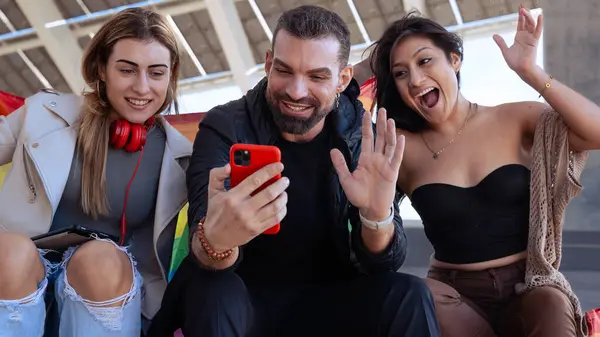 Mutlu çoklu etnik gruptan genç eşcinsel arkadaşlar kampüste bir video görüşmesi yapıyorlar. Şehirde buluşan çok ırklı öğrenciler, gençlik kavramları, insanların yaşam tarzı, çeşitlilik ve gurur..