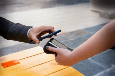 Yakın plan. Kredi kartı tutan ve ödeme yapan genç bir adamın eli..