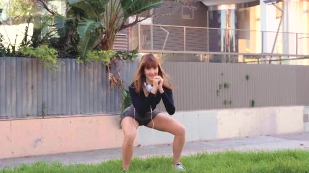 Konzentrierte Junge Frau Mit Sportkopfhörern Macht Kniebeuge — Stockvideo