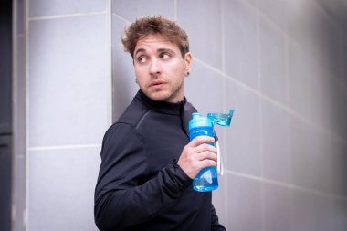 Sporcu adam egzersiz yaparken ciddi içme suyu içiyor..