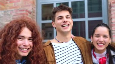 Mutlu çok ırklı öğrenciler kameraya bakmak için kampüste toplandılar. Gençlik kavramları, üniversite hayatı, ergenlik ve şehir hayatı.