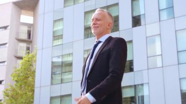 Orta yaşlı mutlu bir adam, parmakları havada profesyonel bir meslektaşıyla konuşuyor..