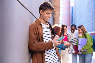 Elinde not defteri olan genç bir öğrenci akıllı telefon uygulamaları ve kablosuz teknolojisi olan sosyal ağlar kullanıyor..