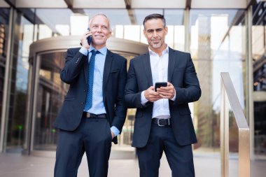 İki Kafkasyalı iş arkadaşı cep telefonuyla konuşuyor, iş çıkışı şehirde dolaşan iş arkadaşları, işten sonra birlikte hoşça kal diyorlar.