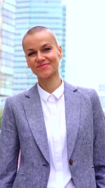  Beyaz iş kadını, dış mekanda duran takım elbiseli kameraya ciddi ciddi bakıyor. Düşünceli bir ifadeyle genç bir avukatın bakışları.