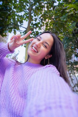 Mutlu genç latin akıllı telefonuyla selfie çekiyor..