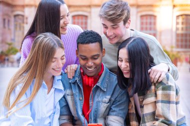 Akıllı telefonlarına bakan bir grup arkadaş kampüste interneti cep telefonuyla tarıyor.