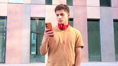  Genç beyaz adam sosyal medyayı akıllı telefon uygulaması ve kablosuz teknolojisiyle kullanıyor..