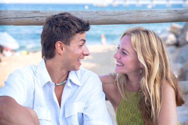 Gülümseyen etnik çeşitlilikte bir kadın ve tatilden zevk alan bir erkek. Z neslinin güzel ve neşeli çifti