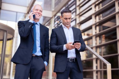 İki Kafkasyalı iş arkadaşı cep telefonuyla konuşuyor, iş çıkışı şehirde dolaşan iş arkadaşları, işten sonra birlikte hoşça kal diyorlar.