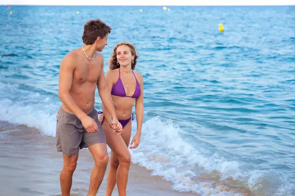  Kafkasyalı çift tatilleri sırasında sahilde yürüyorlar. Tatil, rahatlama ve yaz konsepti