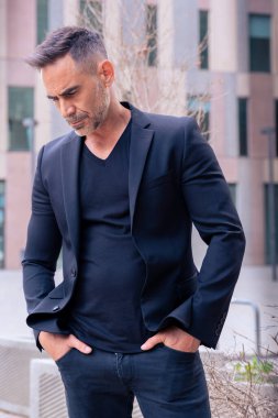 Kafkas işadamı, açık bir çalışma alanında duran takım elbiseli kızgın bir şekilde yere bakıyor. Düşünceli bir ifadeyle genç bir avukatın bakışları.