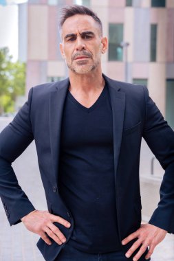 Beyaz bir iş adamının dış mekanda duran takım elbiseli kameraya kızgın bakışları. Düşünceli bir ifadeyle genç bir avukatın bakışları.