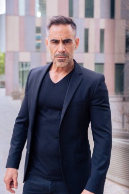 Beyaz bir iş adamının dış mekanda duran takım elbiseli kameraya kızgın bakışları. Düşünceli bir ifadeyle genç bir avukatın bakışları.