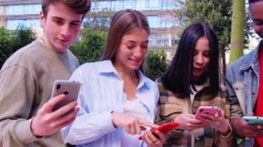 Akıllı telefonlarına bakan bir grup arkadaş kampüste interneti cep telefonuyla tarıyor.