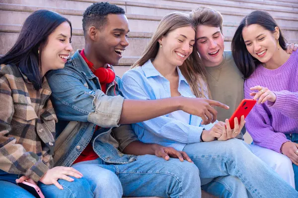 Akıllı telefonlarına bakan bir grup arkadaş kampüste interneti cep telefonuyla tarıyor.