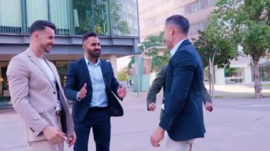 İş ekibi dışarıda başarıyı dostça jestlerle kutluyor. Bir grup profesyonel takım çalışması ve neşeli bir anın tadını çıkarıyor. Takım çalışması, liderlik ve motivasyon temaları için mükemmel.