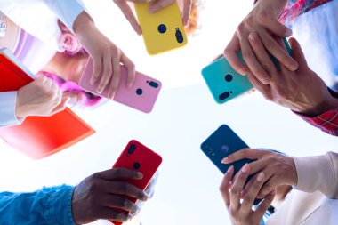  Group A group of friends stands together outdoors, each holding a smartphone. Their phones in different colors are held up, showing connection and teamwork. outdoors clipart