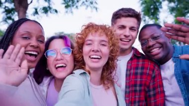 Farklı geçmişlerden beş genç arkadaştan oluşan neşeli bir grup açık havada birlikte poz veriyor. Neşeli ifadeleri ve günlük kıyafetleri canlı ve kapsayıcı bir atmosfer yaratıyor..