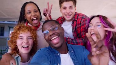 Çeşitli arkadaş grupları neşeli bir selfie çekiyorlar. Gülümsüyor, el sallıyor ve birlikte vakit geçiriyorlar. Parlak, güneşli bir ortamda, dostluklarını ve pozitifliklerini sergiliyorlar..