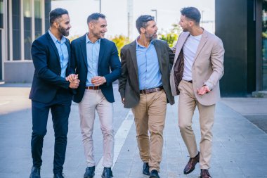 Four businessmen in smart and formal attire walking outdoors in an urban setting, engaged in conversation and showcasing teamwork and professionalism. clipart