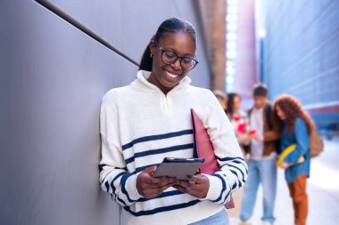 Elinde not defteri olan genç bir öğrenci akıllı telefon uygulamaları ve kablosuz teknolojisi olan sosyal ağlar kullanıyor..