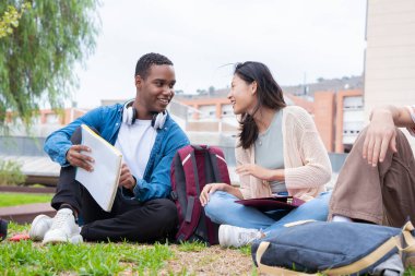 Farklı etnik çeşitlilikteki arkadaşlar dersten sonra dışarıda dinleniyorlar. Üniversite yaşam konsepti