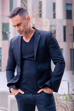 Kafkas işadamı, açık bir çalışma alanında duran takım elbiseli kızgın bir şekilde yere bakıyor. Düşünceli bir ifadeyle genç bir avukatın bakışları.