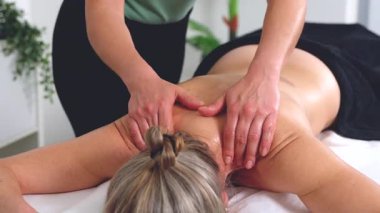 Masaj terapisti, spa seansı sırasında boynuna ve sırtına baskı uyguluyor. Sakin bir ortamda sağlık, rahatlama, sağlık, vücut bakımı ve tedavi amaçlı masaj kavramları için idealdir.. 
