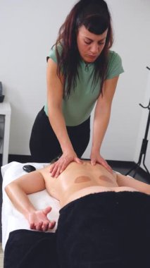 Bir masaj terapisti, sakin bir sağlık odasında müşterilerine baskı uygular. Odaklanmış ve profesyonel, barışçıl ve iyileştirici bir çevrede tedavi edici bakım sağlıyor. Dikey