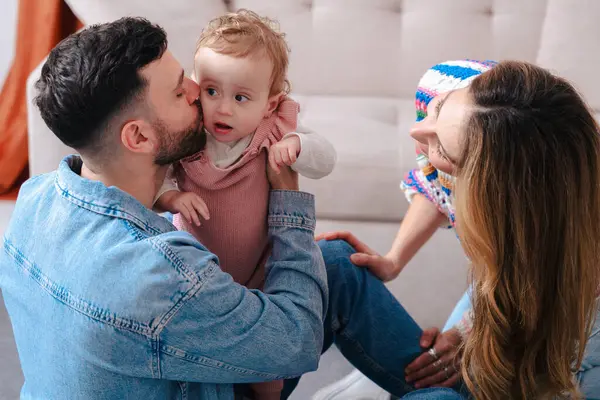 Babasının kucağına aldığı ve küçük kızını öptüğü bir aile anına dokunmak. Kapalı bir alanda yakalanmış. Aşk, çocukluk, ebeveynlik ve duygusal bağlar gibi konular için ideal.. 