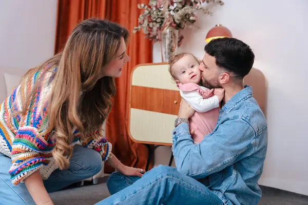 Babasının kucağına aldığı ve küçük kızını öptüğü bir aile anına dokunmak. Kapalı bir alanda yakalanmış. Aşk, çocukluk, ebeveynlik ve duygusal bağlar gibi konular için ideal.. 