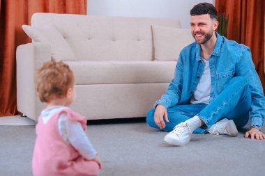 Baba ve kız bebek halının üzerinde kaliteli zaman geçiriyorlar, oynuyorlar, öğreniyorlar, mutlu aile anları, çocukluk gelişimi, babalık, sevgi, ilgi, bağ, rahat oturma odası, birlikte büyüyorlar. 