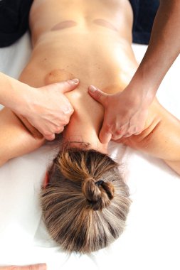 Terapist ellerinin hastaya sıkı baskı uygulaması beyaz masaj masasının üstündeki üst sırt kasları, kas gevşemesi, dokunsal bakım, kapalı alandaki terapi spa tedavisine odaklanıyor. 