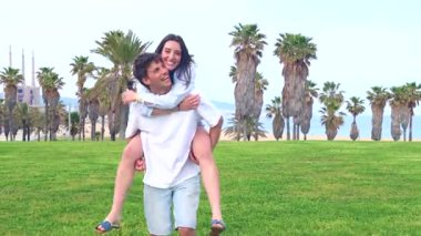 Mutlu genç çift açık havada eğleniyor. Güneşli yeşil bir parkta birlikte yürürken kadını sırtında taşıyan adam, aşkı, neşeyi ve tasasız anları temsil ediyor.. 