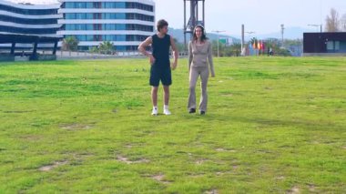 Gülümseyen genç bir çift avuç içi çizgili bir kıyı yolunda yan yana koşuyor, açık hava egzersizinden, spor için mükemmel güneşli ve manzaralı bir ortamda sağlıklı bir yaşam tarzından keyif alıyorlar.. 