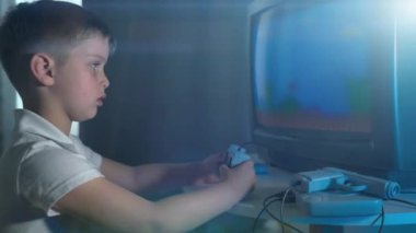 Retro TV 8 bit konsollarında video oyunu oynayan bir çocuk.