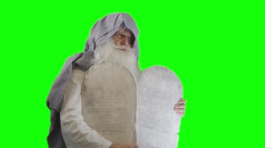 Eski Ahit 'in İncildeki peygamberi Musa, yeşil arka planda on emirle birlikte tabletleri tutuyor.