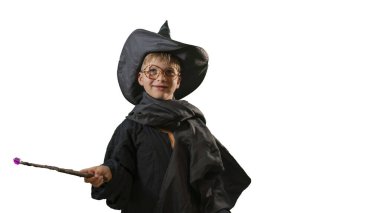 Beyaz arka planda Cadılar Bayramı kostümü giymiş sihirli değneği olan büyücü bir çocuk. 