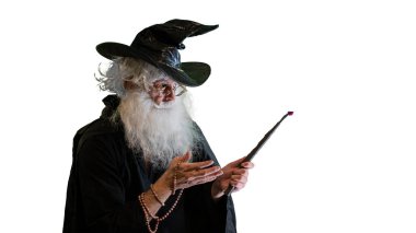 Büyücü yaşlı adam beyaz arka planda sihirli değnekle büyü yapıyor.