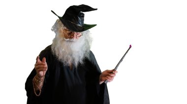 Büyücü yaşlı adam beyaz arka planda sihirli değnekle büyü yapıyor.