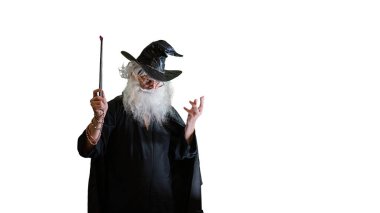 Büyücü yaşlı adam beyaz arka planda sihirli değnekle büyü yapıyor.