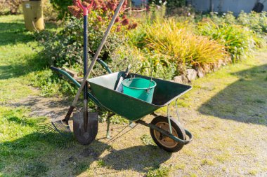 Bahçe Aletleri ve El Arabası Yeşil Çimlerde - Arka bahçede Tırmık, Kürek, Kürek ve Kova