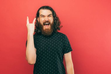 Kaya hareketi gösteren uzun saçlı sakallı adamın yakın portresi..