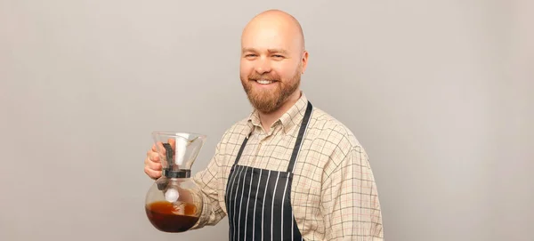 兴奋的秃头男性咖啡师面带微笑 拿着一杯灰色背景的咖啡杯 — 图库照片